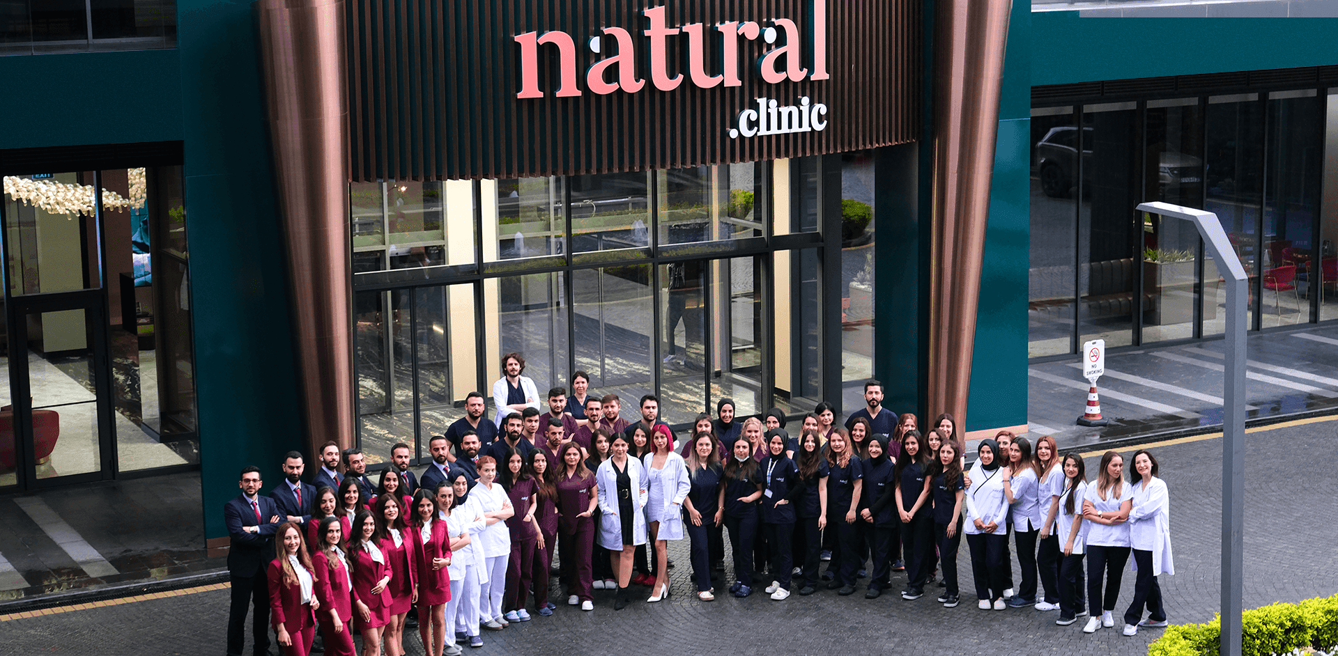 Natural Clinic's full medical and support team standing in front of the clinic's main entrance in Istanbul, Turkey.
