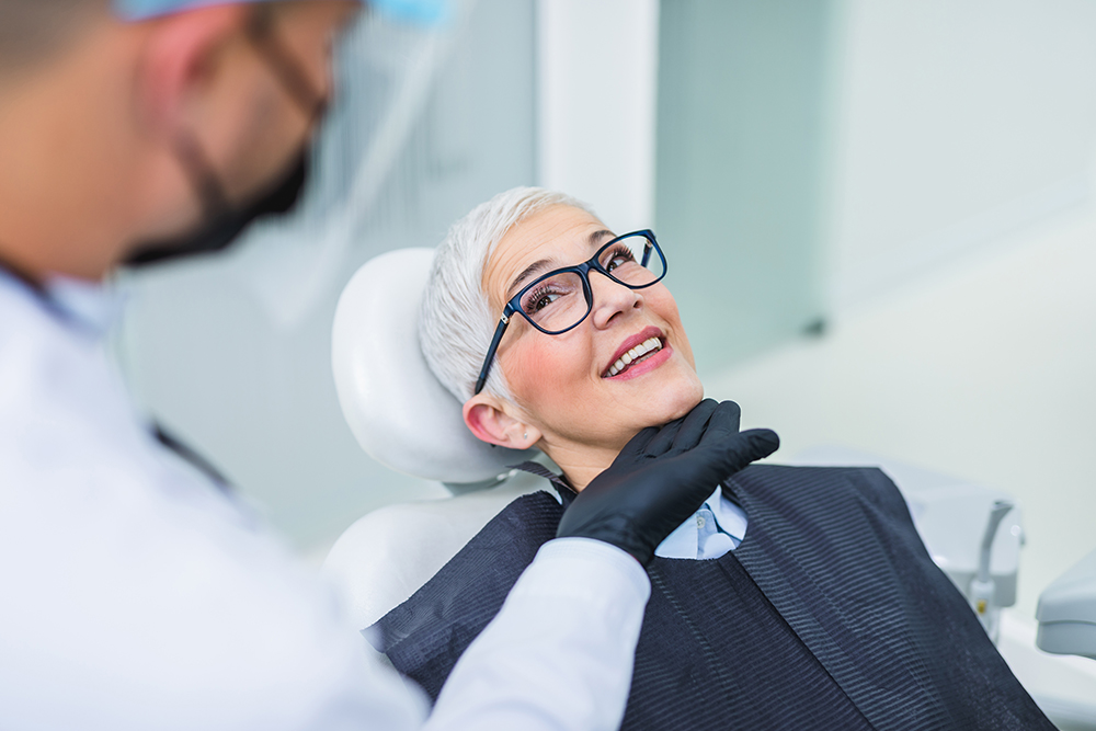 Happy senior woman consulting with dentist before smile makeover treatment in modern clinic