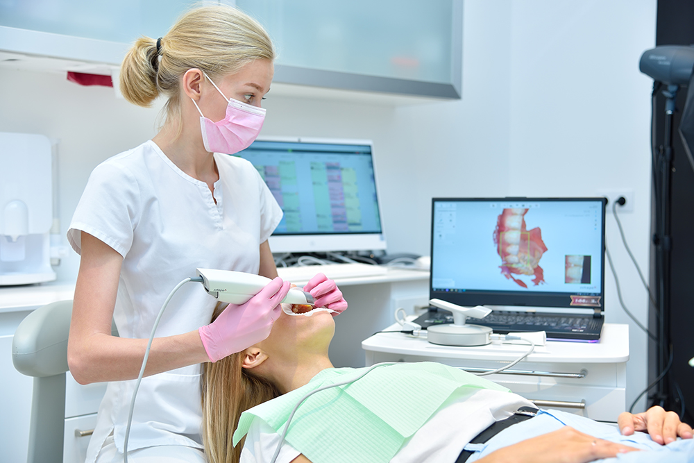 Female dentist using intraoral scanner for advanced dental digital impressions