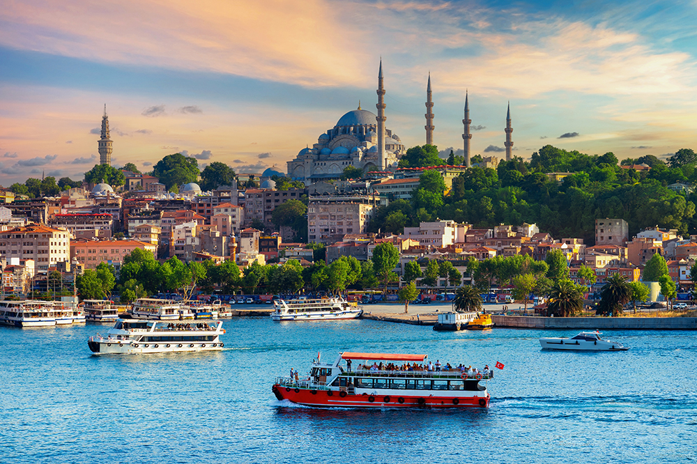 Colorful sunset over Istanbul with Suleymaniye Mosque and Bosphorus ferries in the foreground