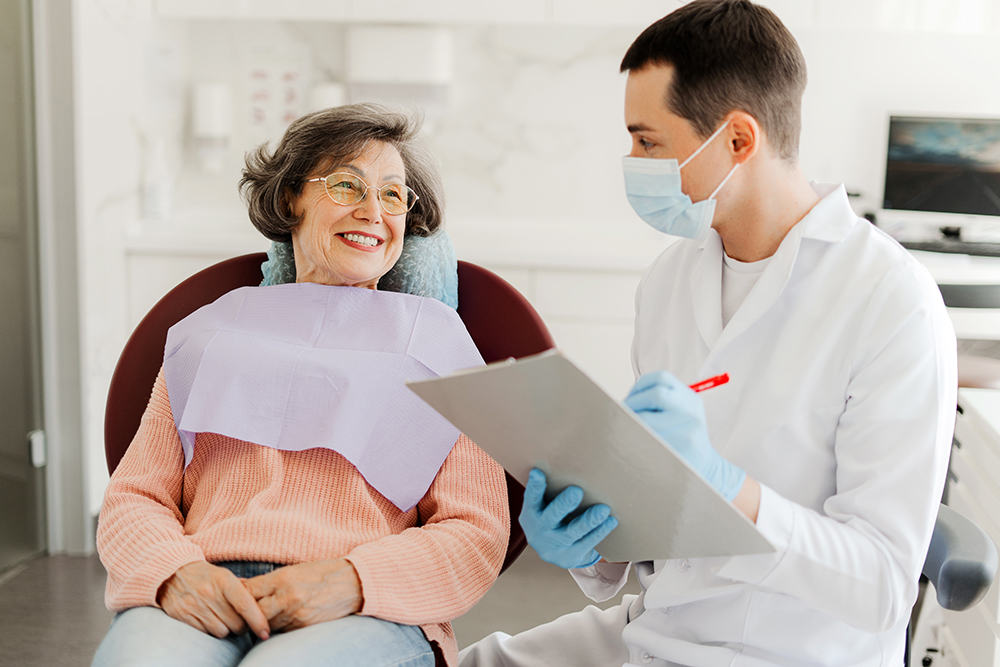Elderly woman smiling during a cosmetic dental consultation with a dentist at Natural Clinic for veneer treatment planning